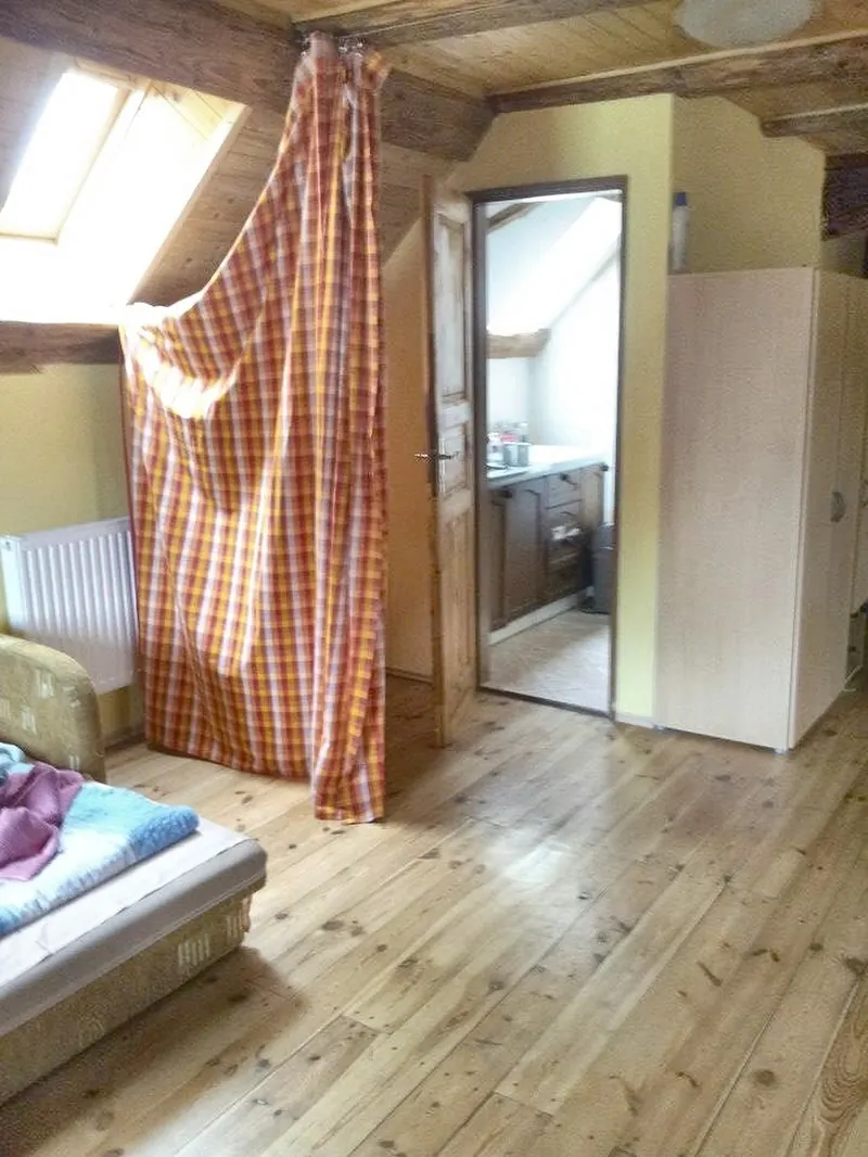 Podkrovní pokoj se střešním oknem a dřevěnou podlahou