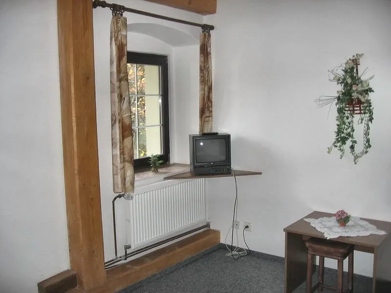 Pokoj s televizí a stolkem u okna